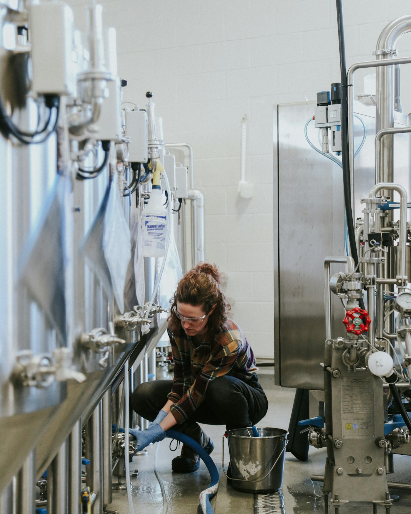 Ruth working the tank valves in the brewhouse