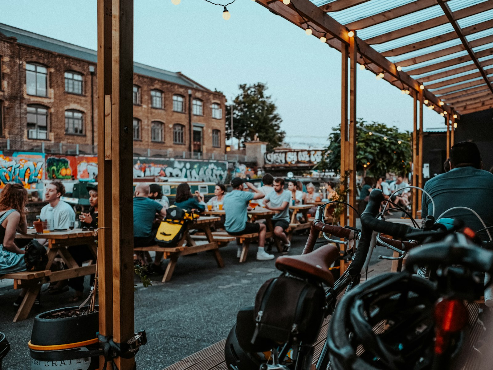 Picnic benches full of people in the brewery yard